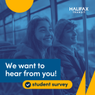 Two students sitting on a transit bus with smiles on their face.